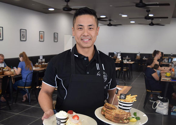 asian waiter serving food in local restaurant